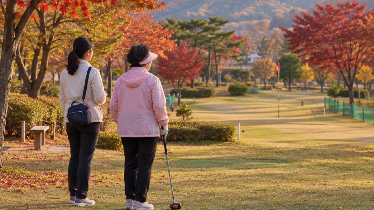 단풍이 붉게 든 가을 파크골프장에서 분홍 바람막이를 입은 어머니와 딸이 나란히 서서 코스를 바라보는 뒷모습 (AI 장면)
